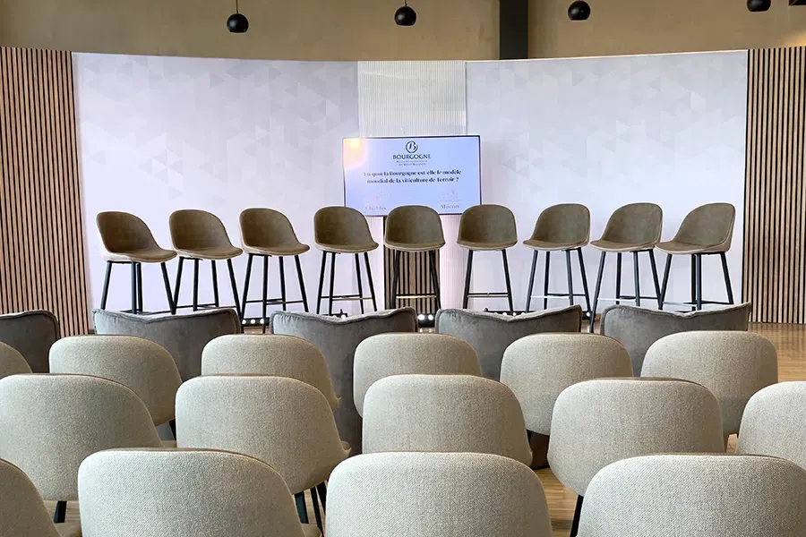 Décor scénique en arc pour table ronde à neuf intervenants devant le public