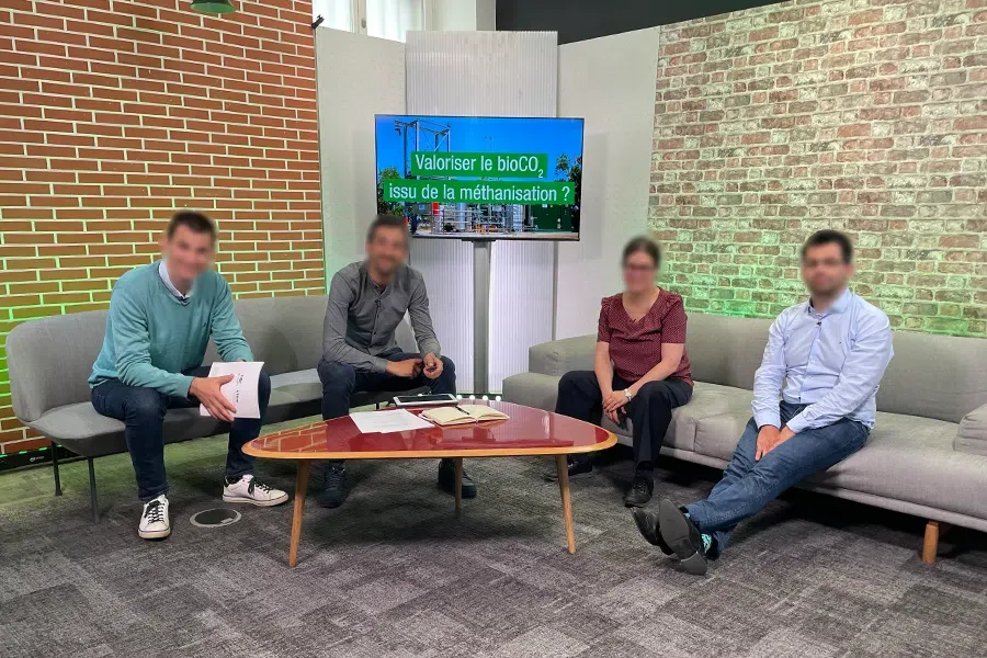 Décor de talk en briques et canapés pour une émission à quatre intervenants